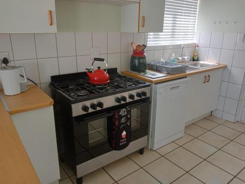 a kitchen with a stove with a tea pot on it at Sea Breeze in Stilbaai