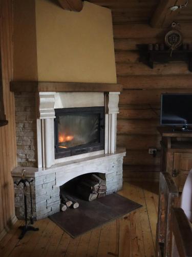 a fireplace in a living room with a fire place at База відпочинку ШИПОВЕЦЬ in Poroškov