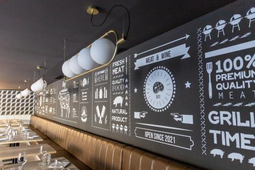 a wall mural in a restaurant with signs on it at The Signature Level at Grand Palladium Sicilia Resort & Spa in Campofelice di Roccella