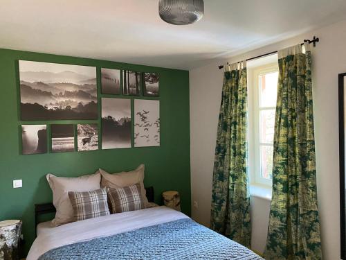 a green bedroom with a bed and a window at Bastide du Soldat in Abreschviller