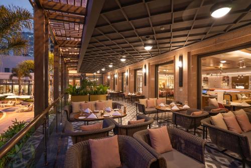 a restaurant with tables and chairs on a balcony at Lotte Hotel Saigon in Ho Chi Minh City