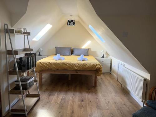 ein Schlafzimmer mit einem gelben Bett im Dachgeschoss in der Unterkunft West End House • Sleeps 8 in Leicester