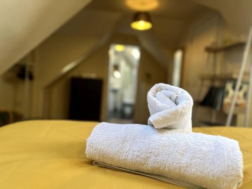 a white towel sitting on top of a bed at West End House • Sleeps 8 in Leicester