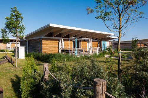 a house with a fence in front of it at Lino delle Fate Eco Resort in Bibione