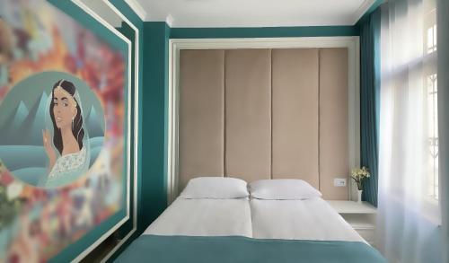 a bedroom with a bed and a painting of a woman at Seven Beauties Hotel Spa Restaurant, Old City Baku in Baku