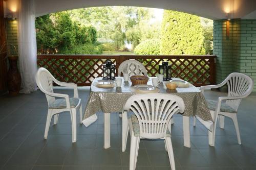 Kis Tisza fishing guest house في Tiszaug: طاولة بيضاء وكراسي على شرفة مع طاولة وكرسي