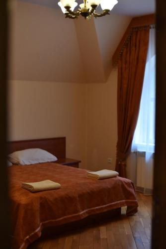 a bedroom with a bed with two towels on it at База відпочинку ШИПОВЕЦЬ in Poroškov