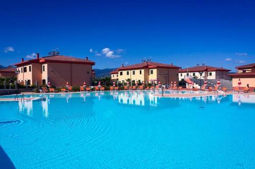 een groot zwembad met blauw water voor gebouwen bij residence afrodite in Solfara Mare