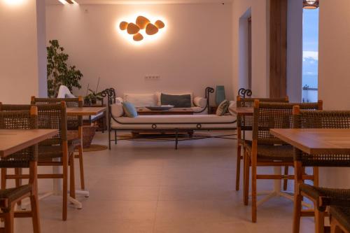 a restaurant with a couch and tables and chairs at Hostal Aigua Clara in Playa Migjorn