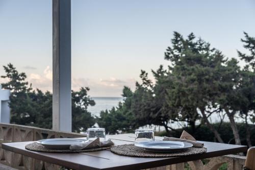 a table with plates and glasses on top of it at Hostal Aigua Clara in Playa Migjorn