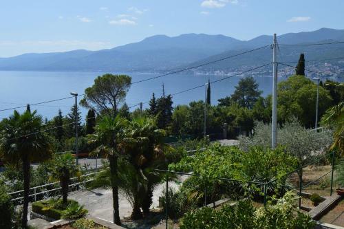 a garden with a view of the water and mountains at Apartment Bella Costa in Rijeka