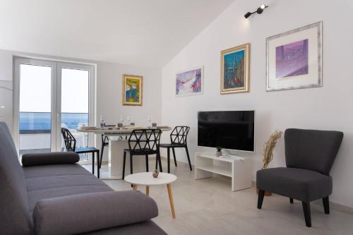 een woonkamer met een bank, een tv en een tafel bij Tomas Deluxe II in Dubrovnik