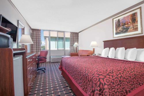 une chambre d'hôtel avec un lit rouge et une télévision dans l'établissement Days Inn by Wyndham Colorado City, à Colorado City