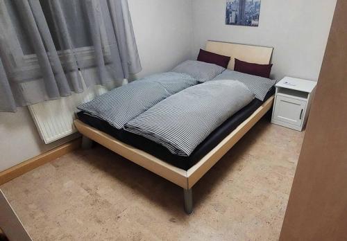 Bett in einem kleinen Zimmer mit Fenster in der Unterkunft Ferienhaus Schafhof in Bad Steben