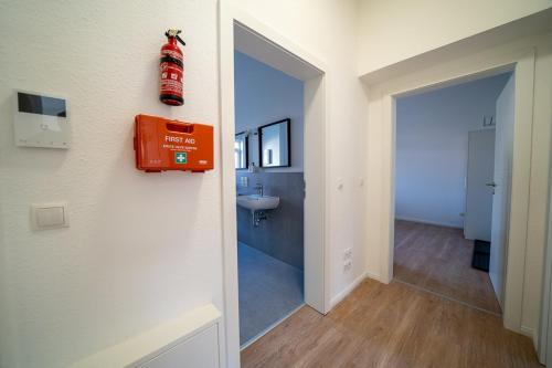 baño con extintor de incendios rojo en la pared en DQ02 - Geräumige Monteurwohnung Koblenz en Coblenza