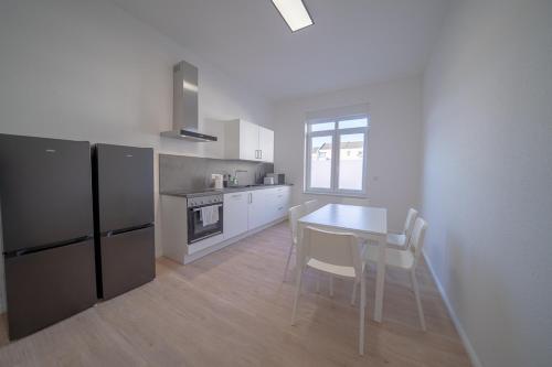 cocina con mesa, sillas y nevera en DQ02 - Geräumige Monteurwohnung Koblenz en Coblenza