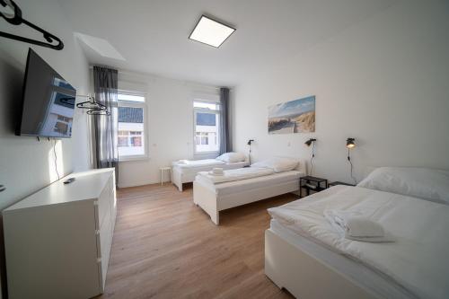 科布倫茨的住宿－DQ02 - Geräumige Monteurwohnung Koblenz，白色的客房配有两张床和电视。