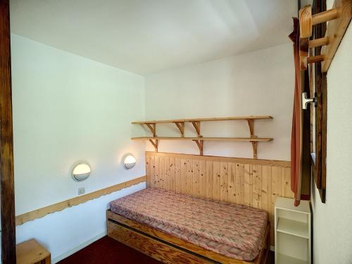Cette petite chambre dispose d'un lit et d'étagères murales. dans l'établissement 2 Pièces 4 Pers au Pied des Pistes avec WiFi et Parking - Les Menuires - FR-1-178-163, aux Menuires