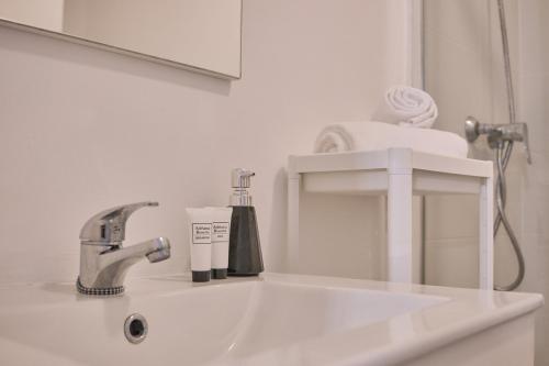 um lavatório de casa de banho com uma torneira e um espelho em Dadá Coliving & Rooms by Serendipia Turismo em Santiago de Compostela