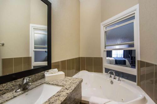 a bathroom with a tub and a large mirror at Comfort Inn & Suites in Fort Saskatchewan