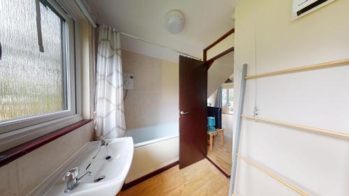 a bathroom with a tub and a sink and a window at 09 Trevithick Court, Tolroy Manor in Hayle