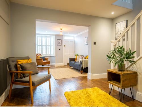 a living room with a couch and a chair at Trinity Cottage in Shottery