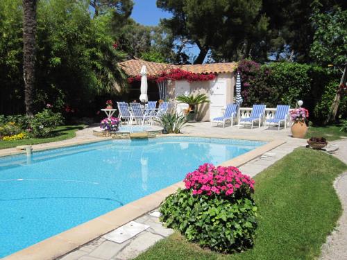 a swimming pool with chairs and flowers in a yard at CASSIS Plage & Calanques in Cassis