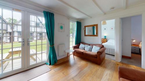 a living room with a couch and a bed and windows at 31 Tudor Court, Tolroy Manor in Hayle