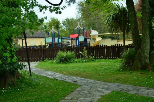 a park with a playground behind a fence at 36 Tudor Court, Tolroy Manor in Hayle