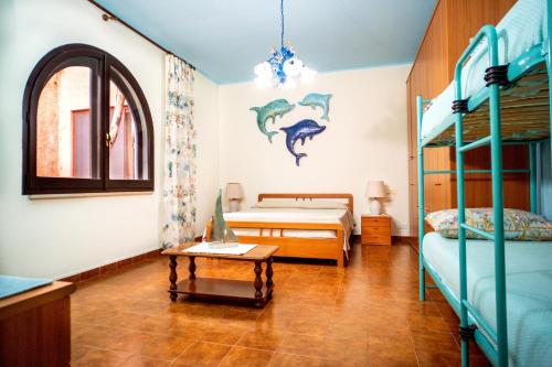 a bedroom with two bunk beds and a table at AFFITTACAMERE SA BRATZA VACANZE in Domus de Maria