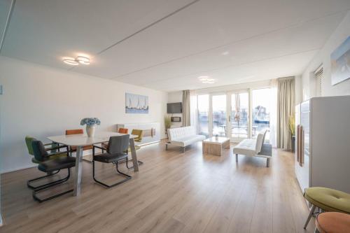 a large living room with a table and chairs at Meerzicht 70 - Vakantiehuis aan het water! in Uitgeest
