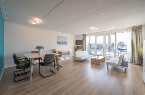 a living room with a table and chairs at Meerzicht 70 - Vakantiehuis aan het water! in Uitgeest
