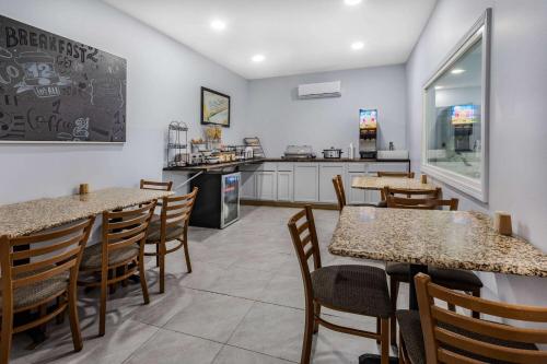 a restaurant with tables and chairs and a kitchen at AmericInn by Wyndham Quincy in Quincy