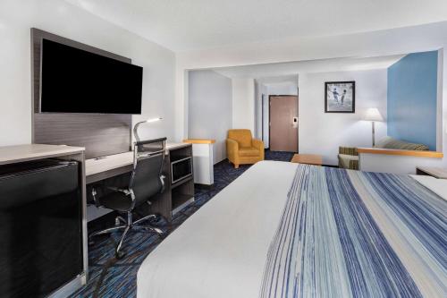 a hotel room with a bed and a flat screen tv at AmericInn by Wyndham Quincy in Quincy
