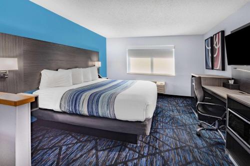 a hotel room with a bed and a desk at AmericInn by Wyndham Quincy in Quincy
