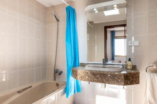 a bathroom with a sink and a tub and a mirror at AT118 Solarium Mar in Torredembarra