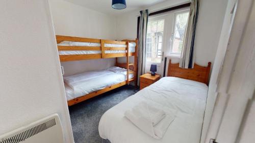 a bedroom with two bunk beds and a window at 15 Tudor Court, Tolroy Manor in Hayle