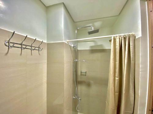 ein Bad mit Dusche und Duschvorhang in der Unterkunft Homey and snuggy 1BR Unit1165 in Manila