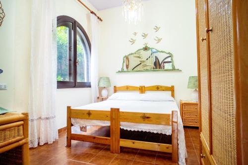 a bedroom with a bed and a window at AFFITTACAMERE SA BRATZA VACANZE in Domus de Maria