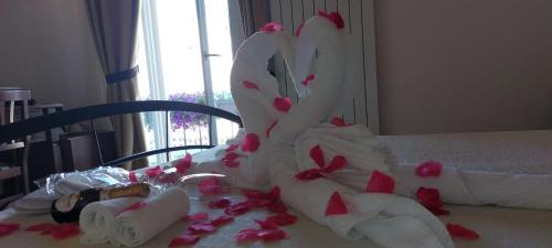 a wedding cake with pink hearts on a table at B&B Corte Regina Esther in Veglie