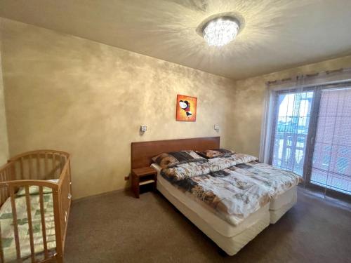 a bedroom with a bed and a crib in it at Comfortable One-Bedroom Apartment TATRAGOLF in Veľká Lomnica