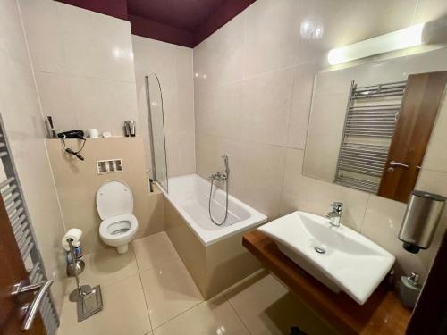 a bathroom with a toilet and a sink at Comfortable One-Bedroom Apartment TATRAGOLF in Veľká Lomnica