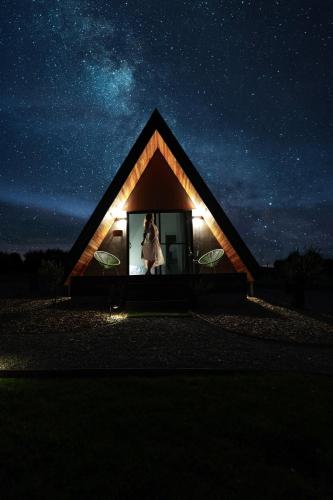 a woman standing in the window of a small house at night at The Cove Tasmania in Devonport