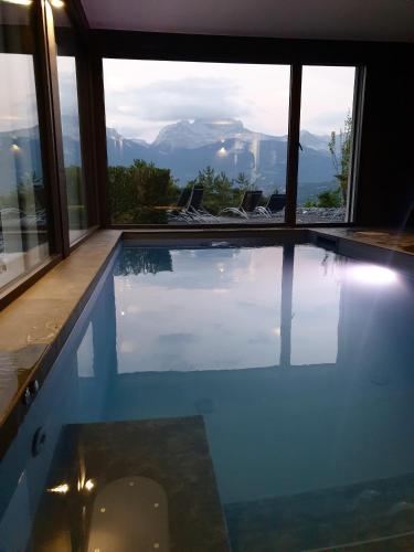 a swimming pool with a view of the mountains at Les Ô d'Annecy in Saint-Jorioz