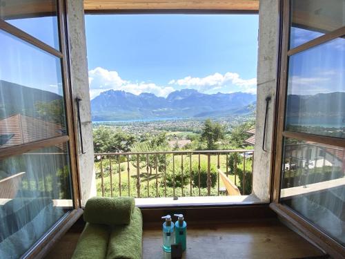 a room with a large window with a view of mountains at Les Ô d'Annecy in Saint-Jorioz