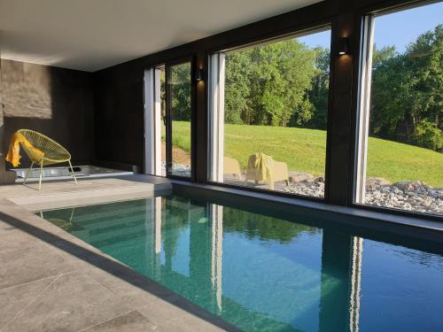 ein Haus mit einem Pool und Fenstern in der Unterkunft Les Ô d'Annecy in Saint-Jorioz