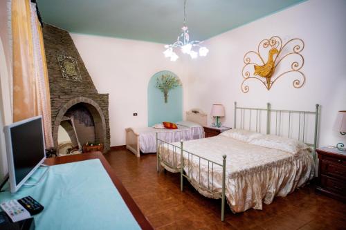 1 dormitorio con 2 camas, TV y chimenea en AFFITTACAMERE SA BRATZA VACANZE en Domus de Maria
