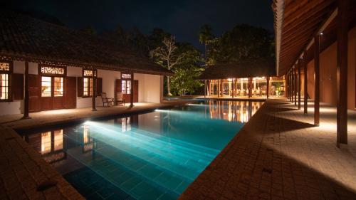 una piscina en un complejo por la noche en Maya Tangalle en Tangalle