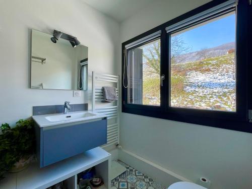 une salle de bain avec un lavabo et une fenêtre dans l'établissement Superbe villa lac d'Annecy avec piscine, à Sévrier