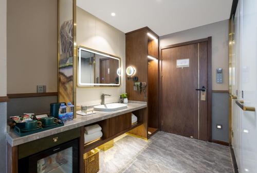 La salle de bains est pourvue d'un lavabo et d'un miroir. dans l'établissement Nostalgia S Hotel - Olympic Sports Center, à Pékin